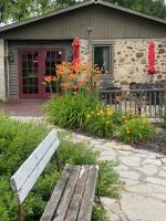 a wooden bench sitting in front of a house at The Inn on the Olde Homestead in Waukesha