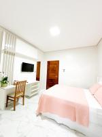 Un dormitorio blanco con una cama grande y una silla. en Hotel Barruada, en Boa Vista