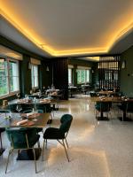 Un comedor con mesas y sillas y ventanas. en Hotel Ristorante Val America, en Tirano