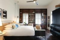 a bedroom with a large white bed and bookshelves at Ridley House - Key West Historic Inns in Key West
