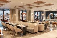 a restaurant with tables and chairs and windows at Elite World Kuşadası in Kusadası