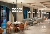 a restaurant with tables and chairs and chandeliers at Elite World Kuşadası in Kusadası