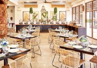 een eetkamer met tafels en stoelen in een restaurant bij TAG Resort in Coron