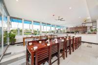 een grote eetkamer met een lange tafel en stoelen bij Hestia HaMy Beach House in Hội An