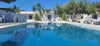 a swimming pool with blue water in a resort at Skiathos Holiday Resort in Skiathos