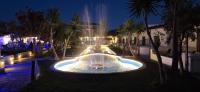 a fountain in the middle of a courtyard at night at Skiathos Holiday Resort in Skiathos