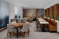 uma sala de jantar com mesas e cadeiras e uma parede em Embassy Suites By Hilton Madison Downtown em Madison