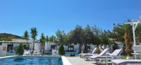 a pool at a hotel with white chairs and trees at Skiathos Holiday Resort in Skiathos
