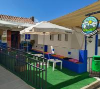 een terras met een parasol en een speelruimte bij Albergue de Lújar in Lújar