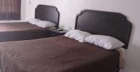 Dos camas en una habitación de hotel con almohadas blancas. en Hotel Estrella, en Matamoros