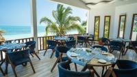 un ristorante con tavoli e sedie e vista sull'oceano di Dream of Zanzibar Resort & Spa - Premium All Inclusive a Uroa