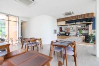 uma sala com mesas e cadeiras e uma cozinha em เดอะซีน คาบาน่า บีช รีสอร์ท ขนอม The Scene Cabana Beach Resort Khanom em Ban Plau