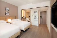 a hotel room with two beds and a large mirror at Sheraton Abu Dhabi Hotel & Resort in Abu Dhabi