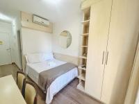 Habitación pequeña con cama y armario en ENB | Ótima Suite hotel em SCS, próx a GM, en São Caetano do Sul