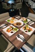 a table with several plates of food on it at Hotel Tamara Melaka in Melaka
