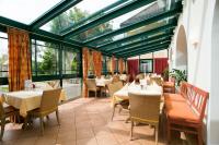 a restaurant with tables and chairs and windows at OptimaMed Gesundheitsresort Bad Wimsbach in Bad Wimsbach-Neydharting