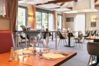 una mesa en un restaurante con copas de vino. en Logis Hotel Restaurant Au Chêne Vert, Saint-Brieuc, en Plérin