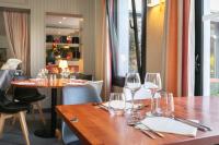 Un restaurante con dos mesas con copas de vino encima. en Logis Hotel Restaurant Au Chêne Vert, Saint-Brieuc, en Plérin