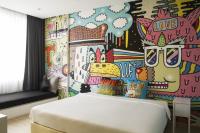 a bedroom with a painted wall with a bed at Beat Hotel Bangkok in Bangkok