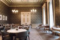een restaurant met tafels en stoelen in een kamer met behang bij Reserve, by Warner Hotels - Heythrop Park in Chipping Norton