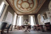 een kamer met een tafel en stoelen en een plafond bij Reserve, by Warner Hotels - Heythrop Park in Chipping Norton