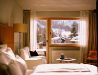 a hotel room with a bed and a window with a view at Hotel Schwarzwand in Lech am Arlberg