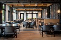 a dining room with tables and chairs and windows at Ada Hotel in Ada