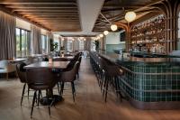 a bar in a restaurant with tables and chairs at Ada Hotel in Ada