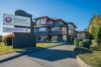 un edificio con un cartel delante de una casa en Coast Parksville Hotel, en Parksville