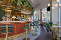 a bar at a restaurant with green stools at DoubleTree by Hilton London Chelsea in London