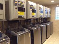 a row of washers and dryers lined up in a room at Kindness Hotel - Kaohsiung Main Station in Kaohsiung