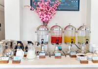 un comptoir avec des boissons de différentes couleurs dans des bocaux en verre dans l'établissement ARECA HOTEL NHA TRANG, à Nha Trang