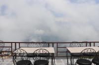 um grupo de mesas e cadeiras numa varanda em Suryachaur Nature Retreat em Thāpāgāon