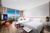 a hotel room with two beds and a television at W Dubai - Mina Seyahi in Dubai