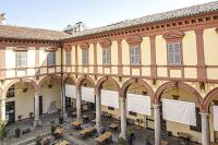 un gran edificio con mesas y sillas en un patio en Hotel Tornielli 9 by LVG Hotel Collection, en Novara