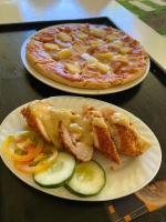 deux assiettes de nourriture sur une table avec une pizza dans l'établissement Vhora Resort, à Magdiwang