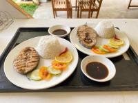 trois assiettes de nourriture sur un plateau avec du riz et des légumes dans l'établissement Vhora Resort, à Magdiwang