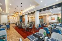 ein Restaurant mit Tischen und Stühlen in einem Raum in der Unterkunft Beijing Feitian Hotel in Peking