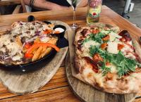 セフェーヌムにあるKnus boomstamhuisje op de Schatberg - nabij Toverlandのピザ2枚とピザパンが置かれたテーブル