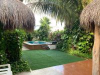 un patio trasero con piscina y césped verde en Casa Nona Azul, en Cancún