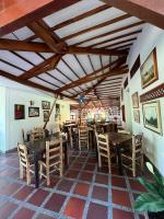 Un comedor con mesas y sillas de madera. en Hotel Pueblito Cafetero, en Pereira