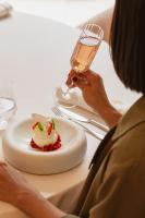 una mujer sentada en una mesa con una copa de vino en La Maison d'Uzès Relais & Châteaux, en Uzès