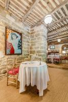Un comedor con una mesa en una pared de piedra. en La Prévôté - Luxury Chambres d'hôtes & Gastronomic Restaurant, en LʼIsle-sur-la-Sorgue