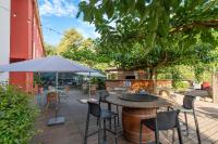 een terras met een tafel, stoelen en een parasol bij Best Western Terre de Provence in Le Cannet-des-Maures