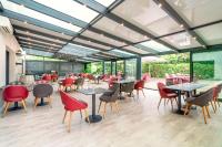 een eetkamer met tafels en stoelen en ramen bij Best Western Terre de Provence in Le Cannet-des-Maures