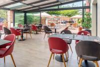 een restaurant met tafels, stoelen en ramen bij Best Western Terre de Provence in Le Cannet-des-Maures