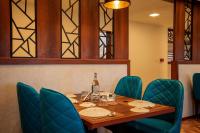 een tafel met stoelen en een fles wijn erop bij Kumbanad Heritage Hotel in Vennikulam