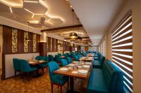 een restaurant met houten tafels en blauwe stoelen bij Kumbanad Heritage Hotel in Vennikulam