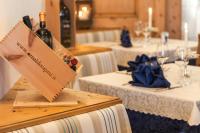 Una mesa con una botella de vino encima. en Family Hotel La Perla, en Fiera di Primiero