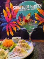 a table with a plate of food and a wine glass at El Jardín Escondido by Soma in Baños